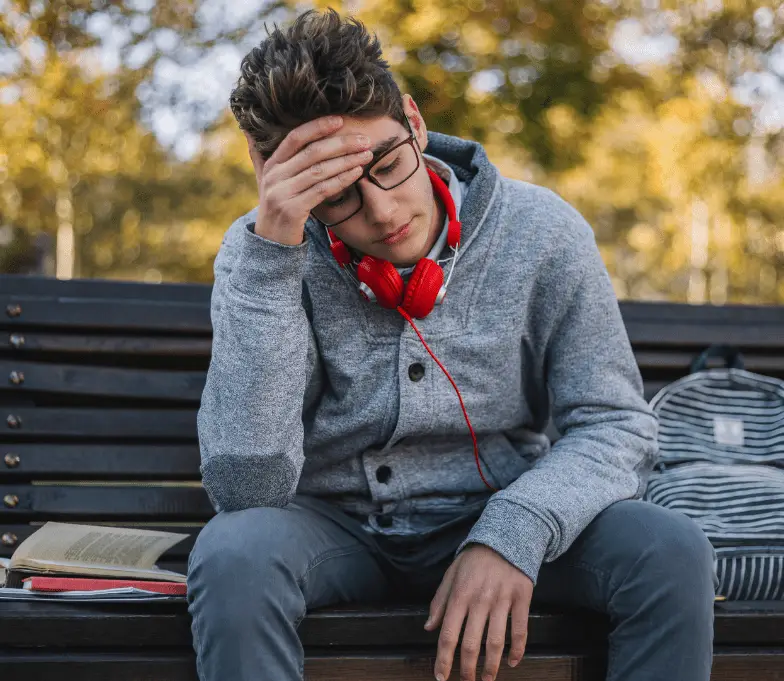 A young man undergoing exposure therapy for Obsessive Compulsive Disorder while sitting on a bench.