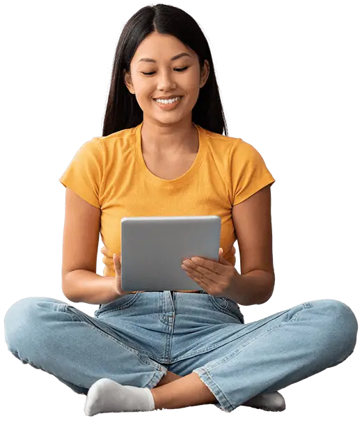 A young woman sitting on the floor and using a tablet computer.