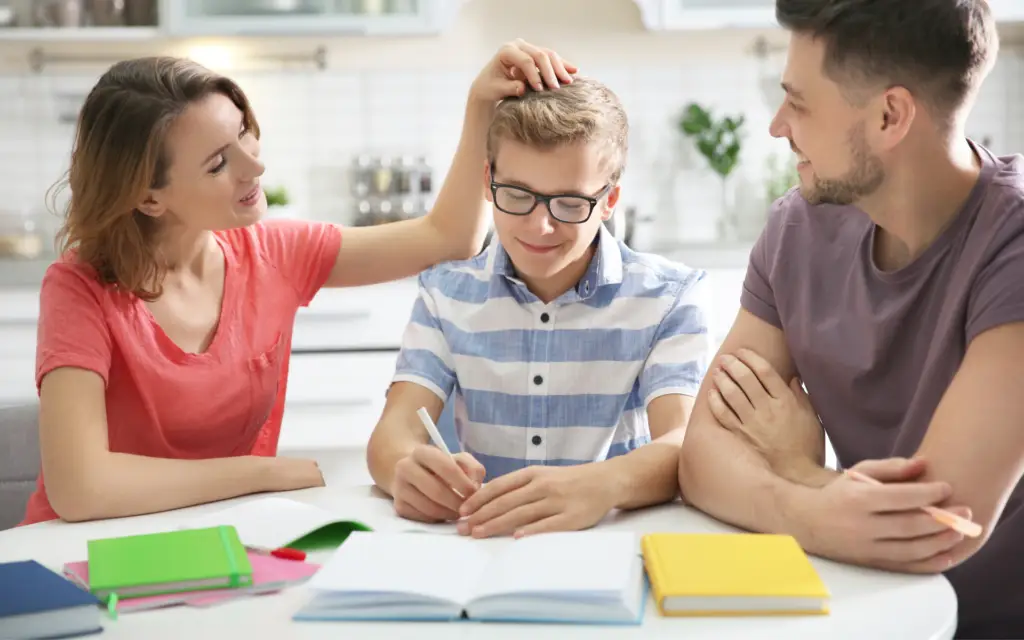 A family participates in the BrainBehaviorReset™ Program while a boy is writing in a notebook.