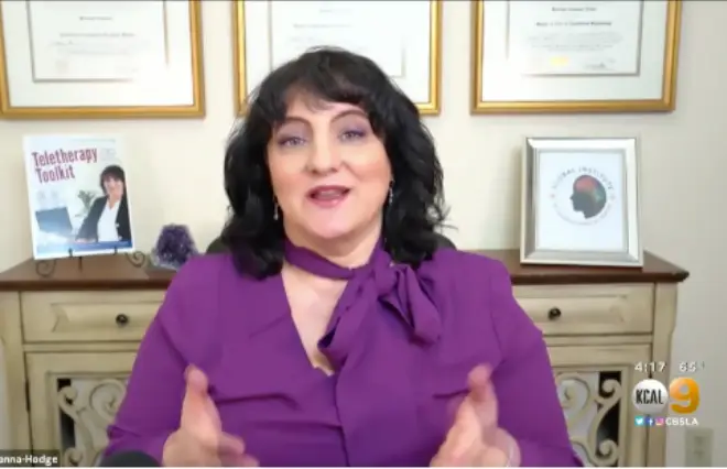 A woman in a purple shirt is delivering a speech into a microphone for the media kit.