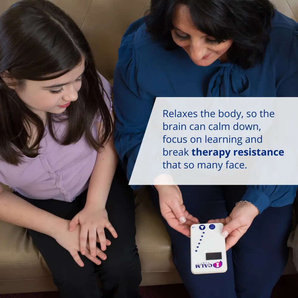 A woman is holding a Calm PEMF™ device, designed to enhance attention and learning capabilities.