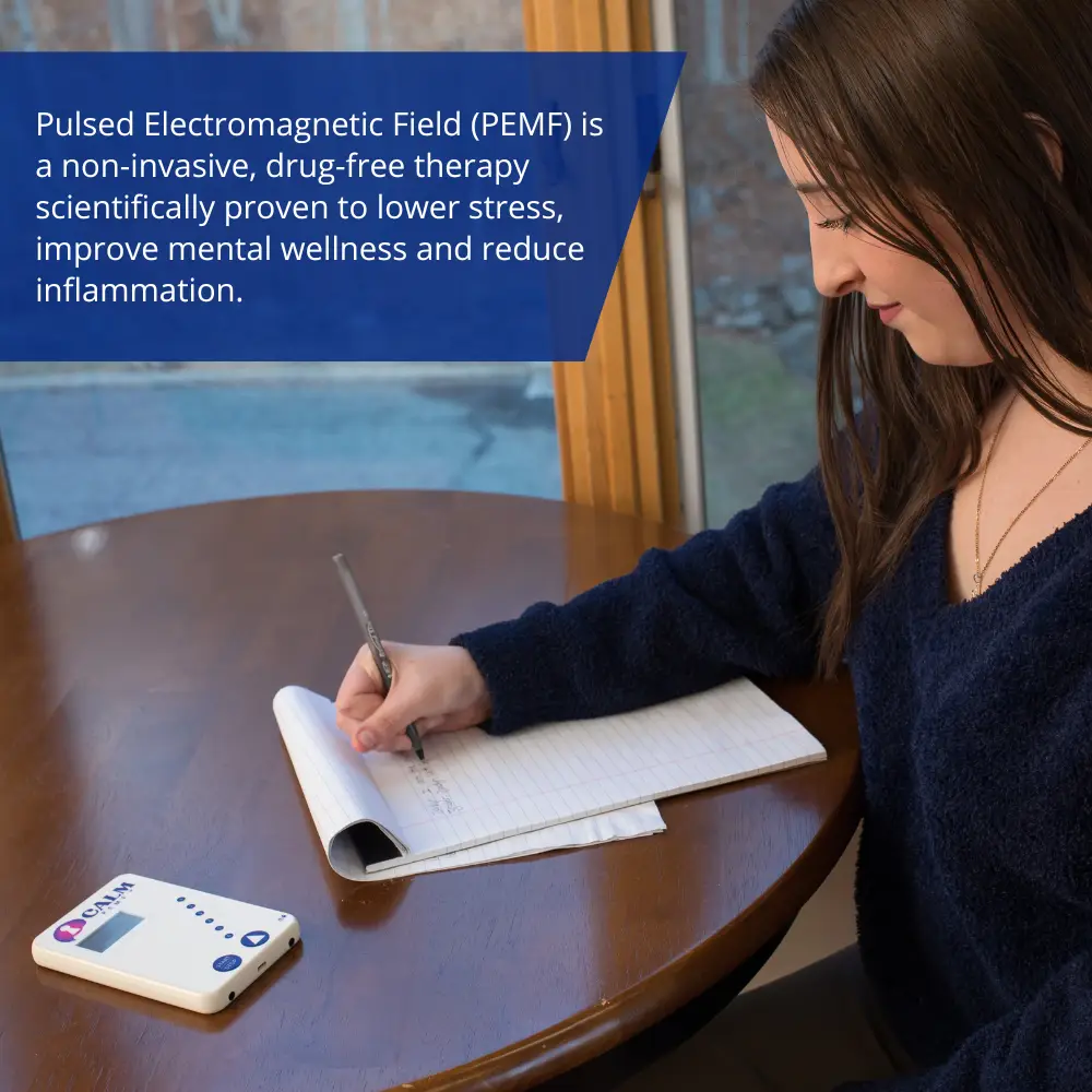 A woman peacefully writing in a Calm PEMF™ - Attention and Learning notebook.