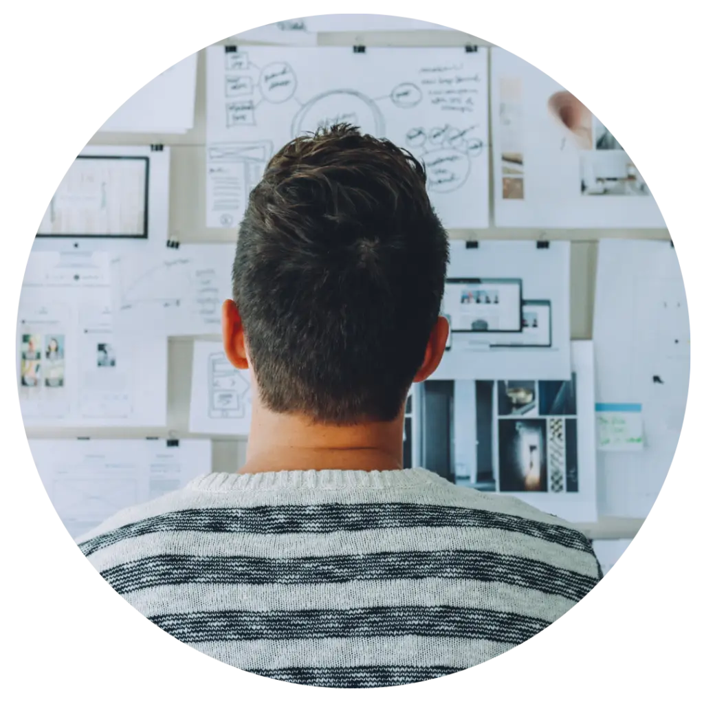 A CALM man standing in front of a wall full of notes.