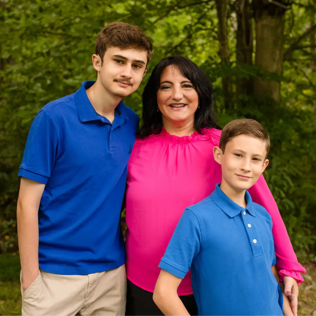 A family posing for a photo in the woods.
