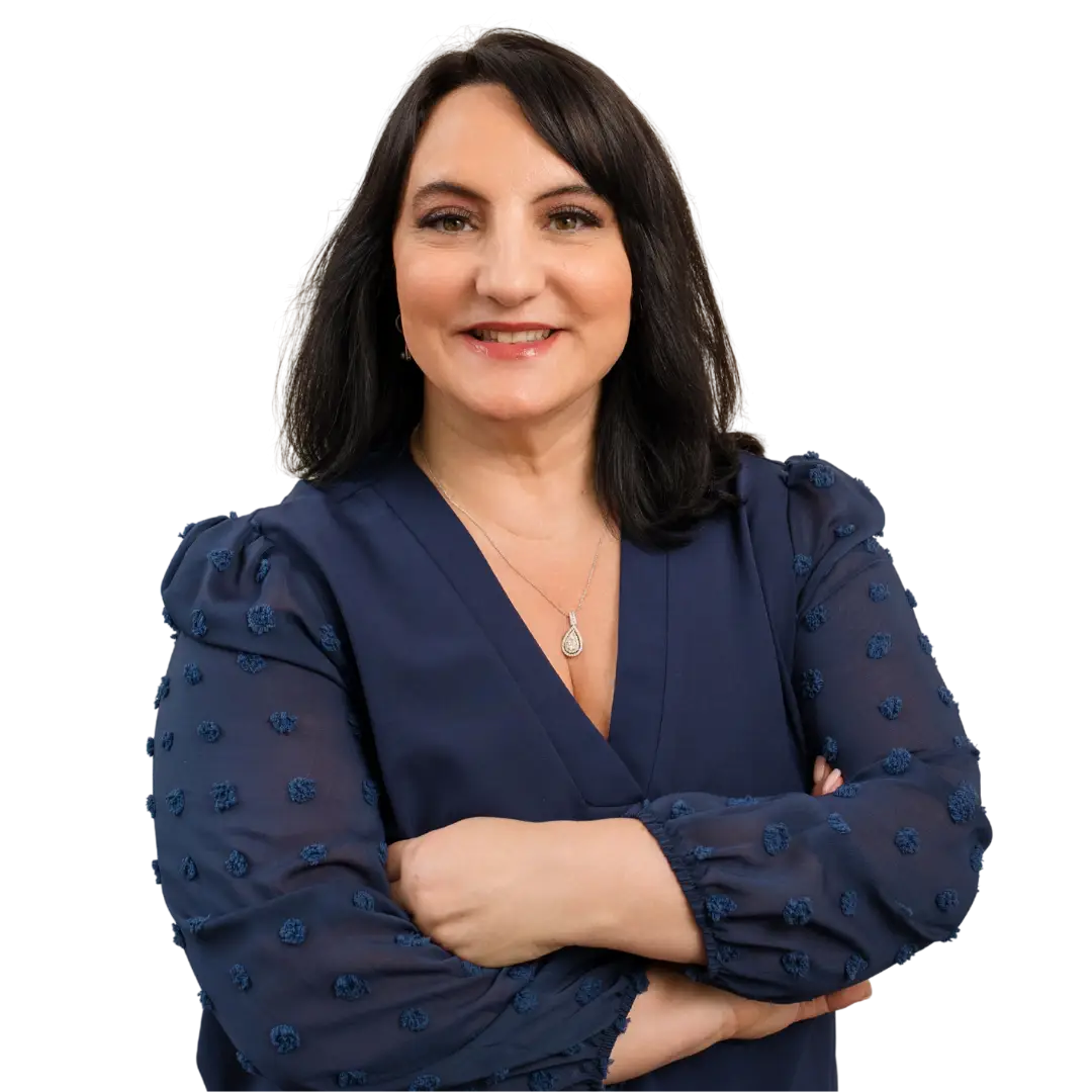 Portrait of Dr. Roseann Capanna-Hodge standing confidently with arms crossed, smiling warmly, dressed professionally, conveying expertise, compassion, and authority in mental health care.