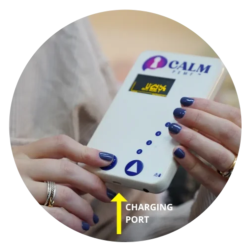 A calm woman is holding a PEMF device with a charging port.