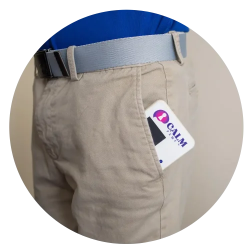 A calm man sporting a belt with a card tucked in his pocket.