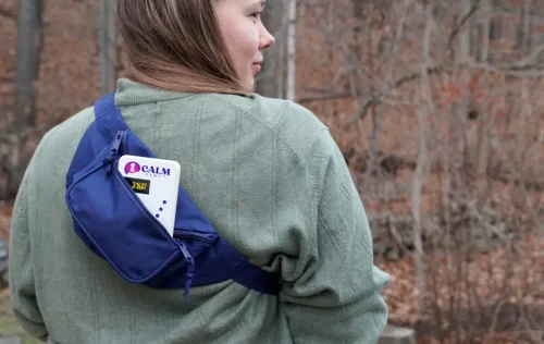 A woman wearing a blue CALM fanny pack.